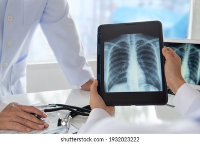 Radiology And Medicine Concept. Doctor Explaining The Results Of Scan Lung On Digital Tablet Screen To Patient.