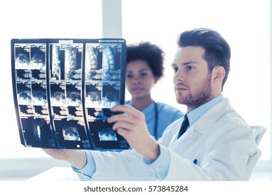 radiology, surgery, health care, people and medicine concept - doctor and nurse looking at x-ray image of spine at hospital - Powered by Shutterstock