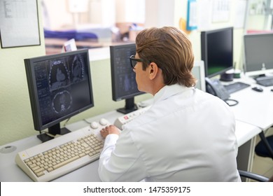 Radiology Technologist Looking At Monitor With CT Scan Images Stock Photo