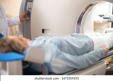 Radiology Technologist Using CT Scan To Examine Young Lady Stock Photo