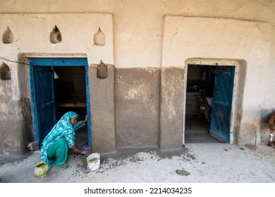 Raebareli; Uttar Pradesh, India-Aug 7 2015: Indian Women Cleaning The House Front With Cow Dung, A Village Life In Raebareli. Woman Repairing House Wall With Mud And Cow Dung Mixture