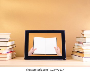 Raeding Book In Tablet Pc And Stack Book On Wooden Table