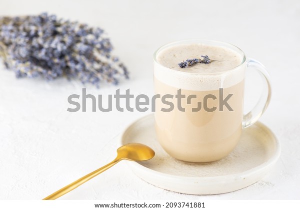 Raf coffee with coconut milk and lavender in a\
glass mug on the table.