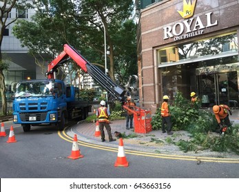 Raffles Place, Singapore - May 20, 2017 : Indian Male Workers Cutting And Trimming Tall Trees In The CBD Area With A Help From Crane Truck