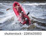 Raft boat during whitewater rafting extreme water sports on water rapids, kayaking and canoeing on the river, water sports team with a big splash of water, 3 persons in a raft boat
