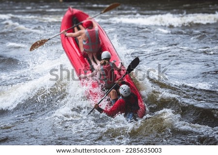 Raft boat during whitewater rafting extreme water sports on water rapids, kayaking and canoeing on the river, water sports team with a big splash of water, 3 persons in a raft boat
