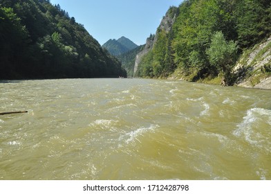 
Rafting on the Dunajec River in the Pieniny National Park on wooden folding shuttles tied with a rope. Rafters paddling on a rapid stream with a rocky bottom and strong river current.