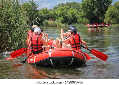  Rafting Team , Summer Extreme Water Sport.  Group Of People In A Rafting Boat, Beautiful Adrenaline Ride Down The River. Back View. POV