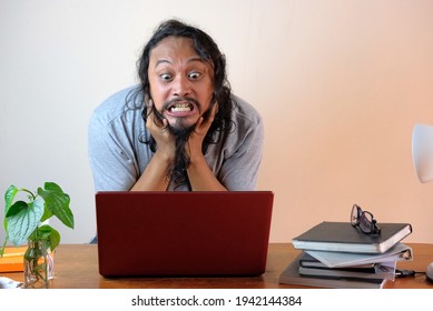 rage asian man in front laptop, stressed casual guy while working at home, funny frustrated expression