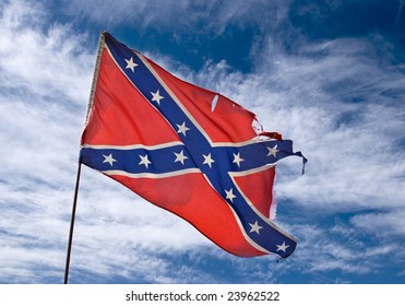 Ragged Confederate Flag Flying Against Sky