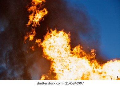 Raging flames of huge fire at night. Firestorm close up. Burning fire full frame. Bright inferno flames. Hell fire explosion. Blaze fire texture. Burning bright Bonfire. Intense combustion and heat. 