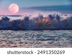 Raging seascape of full moon rising over ocean waves crashing against the shore, Stormy scene capturing the ethereal beauty of nature under the night sky. Background for Halloween.