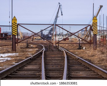 Rail Road Tracks Under The Gantry Cranes On The Berth Of Sea Merchant Port