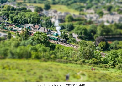 Rail station with Steam Train departing and green fields