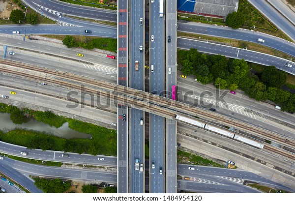 Rail\
track and conductor rail transportation top view, Road Expressway\
traffic an important infrastructure with moving cars and railway\
tracks on which the train rides in Bangkok\
Thailand.
