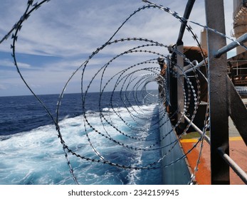 The​ crews​ prepared​ razor​ wire​ at​ ship​ railing for​ anti-piracy​ attack while​ passage high​ risk​ area