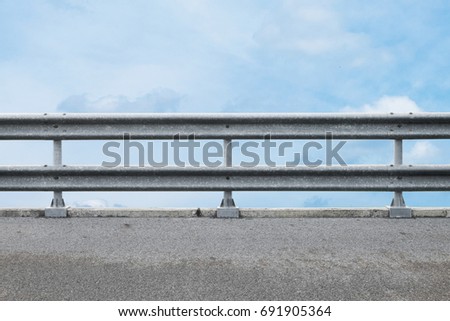railing at road side on blue sky background