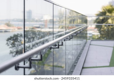 A railing with a view of a city and water. The railing is made of glass and metal - Powered by Shutterstock