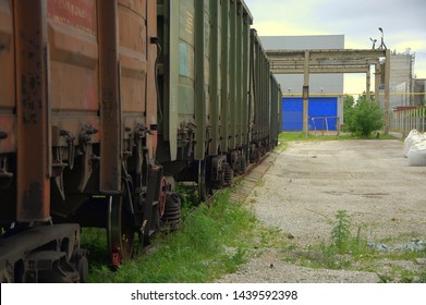 Railroad cars in a dead end at an old abandoned factory at the blue gate of the warehouse.