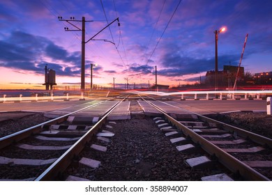 Railroad Crossing With Car Lights In Motion At Night.