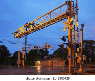 Railroad Crossing Gates With Small Town Diner In Background