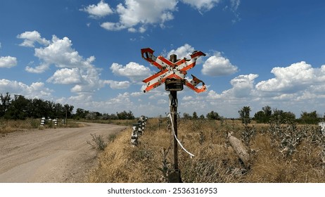 Railroad crossing sign. Red sign is riddled with bullet holes and shrapnel from mines and shells, war in Ukraine - Powered by Shutterstock