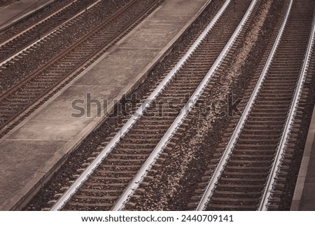 Railroad, empty rails outdoors. Top view, perspective. Shiny iron rails and concrete sleepers, coupled with powerful bolts on stony ground. 