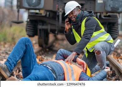 Railroad engineer injured in an accident at work on the railway tracks. Calling for help