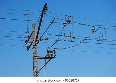 Railroad overhead lines against clear blue sky. Contact wire