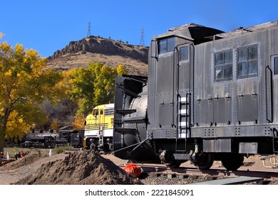 Railroad Rotary Snow Plow Near a Yellow Diesel Electric Locomotive with a Historic Steam Locomotive Fired Up and Fall Leaf Colors - Powered by Shutterstock