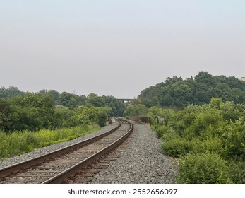 Railroad track snaking around lush greenery - Powered by Shutterstock