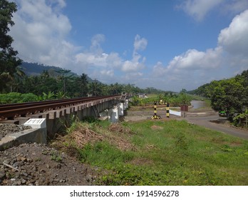 The Railroad Tracks Above The Highway And Under The Blue Sky