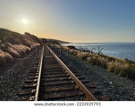 Railroad tracks along the Pacific Ocean shore near Santa Barbara during sunrise