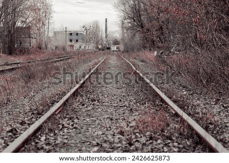 Railroad tracks to an old abandoned factory. The railway tracks. Landscape with railroad leading lines