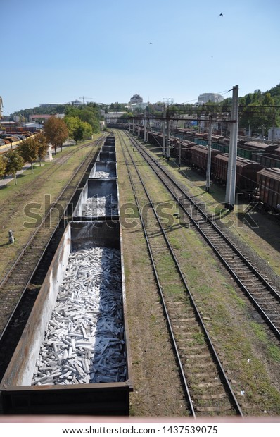 Railroad tracks: rails and\
sleepers go into the distance. Open and closed freight cars. View\
from above.