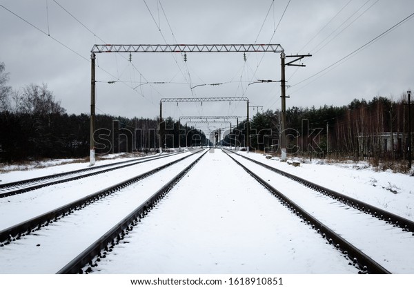 Railroad\
tracks in winter. The image of a winter view of the railroad\
tracks. Background of train tracks in\
winter.