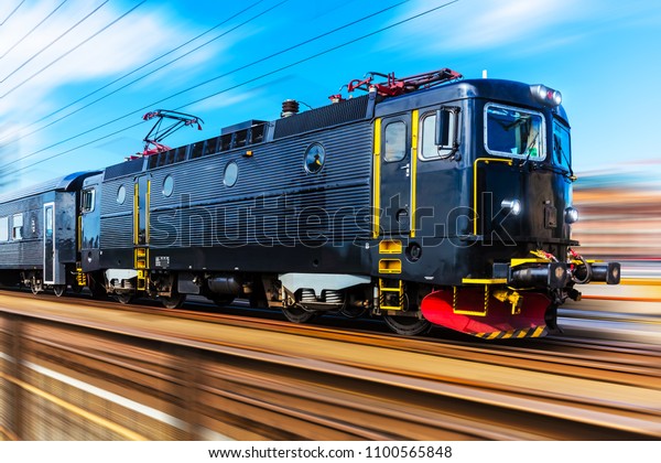 Railroad travel and\
railway tourism transportation industrial concept: scenic summer\
view of modern high speed passenger commuter train on tracks with\
motion blur effect
