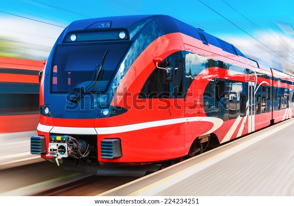 Railroad travel and railway tourism transportation\
industrial concept: scenic summer view of modern high speed\
passenger commuter train on tracks at the station platform with\
motion blur effect