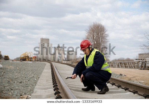 Railroad worker\
checking tracks for railway\
train