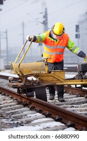 A Railroad Worker Repairs Rails With His Machine