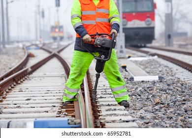 A Railroad Worker Unscrews A Screw On The Rails