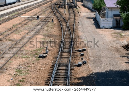 Railway, Complex track layout featuring mainline, sidings, points, frogs. Switch stands, insulated joints. Signal apparatus, semaphore. Maintenance road platform and station infrastructure
