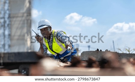 Railway construction supervisor using walkie talkie to coordinate rail installation, Industrial engineer inspecting railway tracks and giving instructions via radio at a construction site