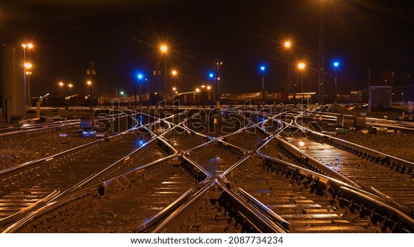railway marshalling\
yard in the evening. in the photo, railway tracks, arrows and\
bright lighting\
spotlights