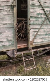 Railway Old Wooden Freight Car With The Door Ajar Where A Wooden Cart Is Visible Inside.