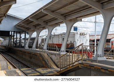 Railway platform with train and modern structural canopy, showcasing transportation infrastructure and urban travel environment in daylight.