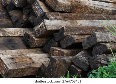 railway sleeper texture background brown weathered wood stack of old wooden beams outdoors in daytime concept of transportation, construction, industrial materials. 