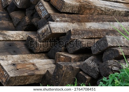 railway sleeper texture background brown weathered wood stack of old wooden beams outdoors in daytime concept of transportation, construction, industrial materials. 