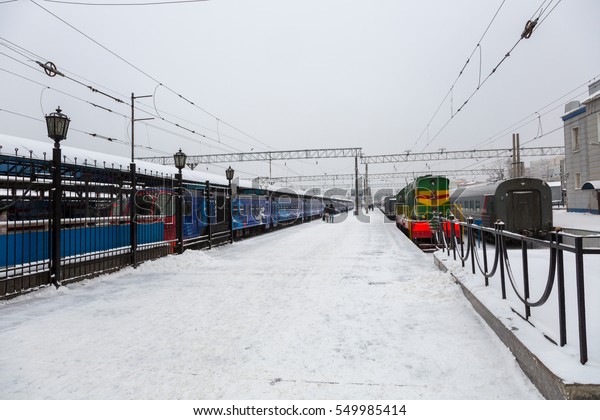 Railway\
station with passenger train in the snow\
winter