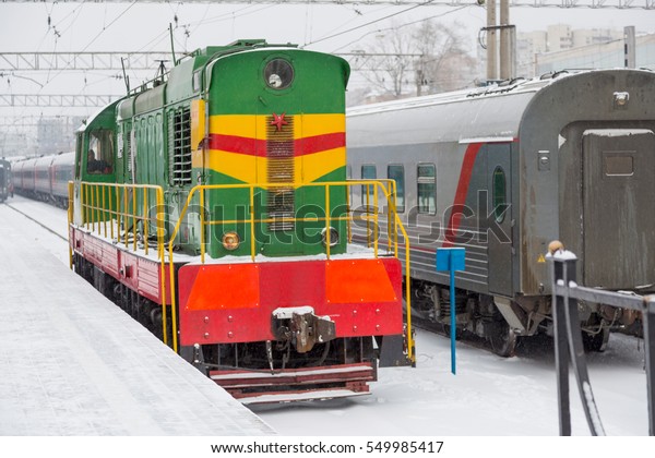 Railway\
station with passenger train in the snow\
winter